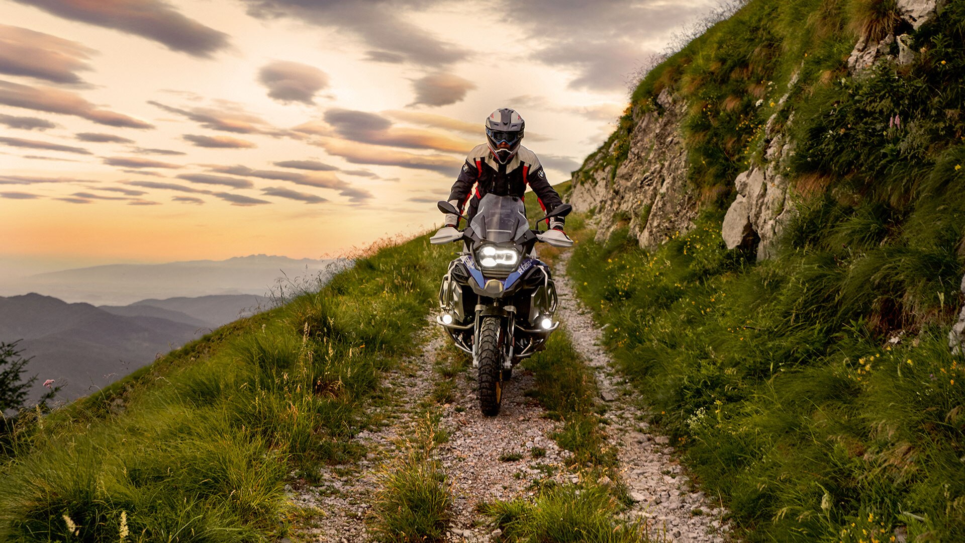 Сцена движения на BMW R 1250 GS Adventure в горах по грунтовой дороге