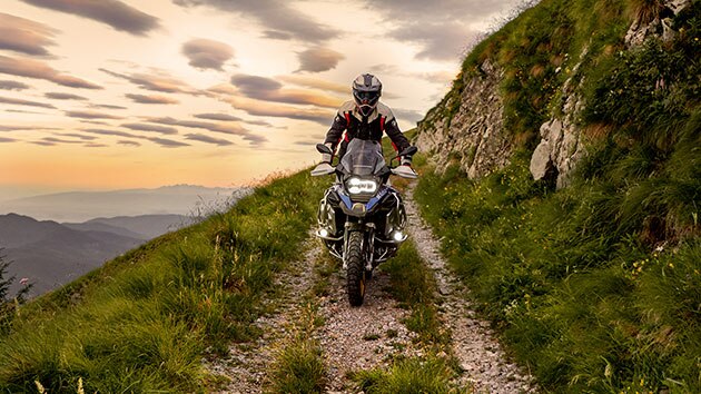 Сцена движения на BMW R 1250 GS Adventure в горах по грунтовой дороге